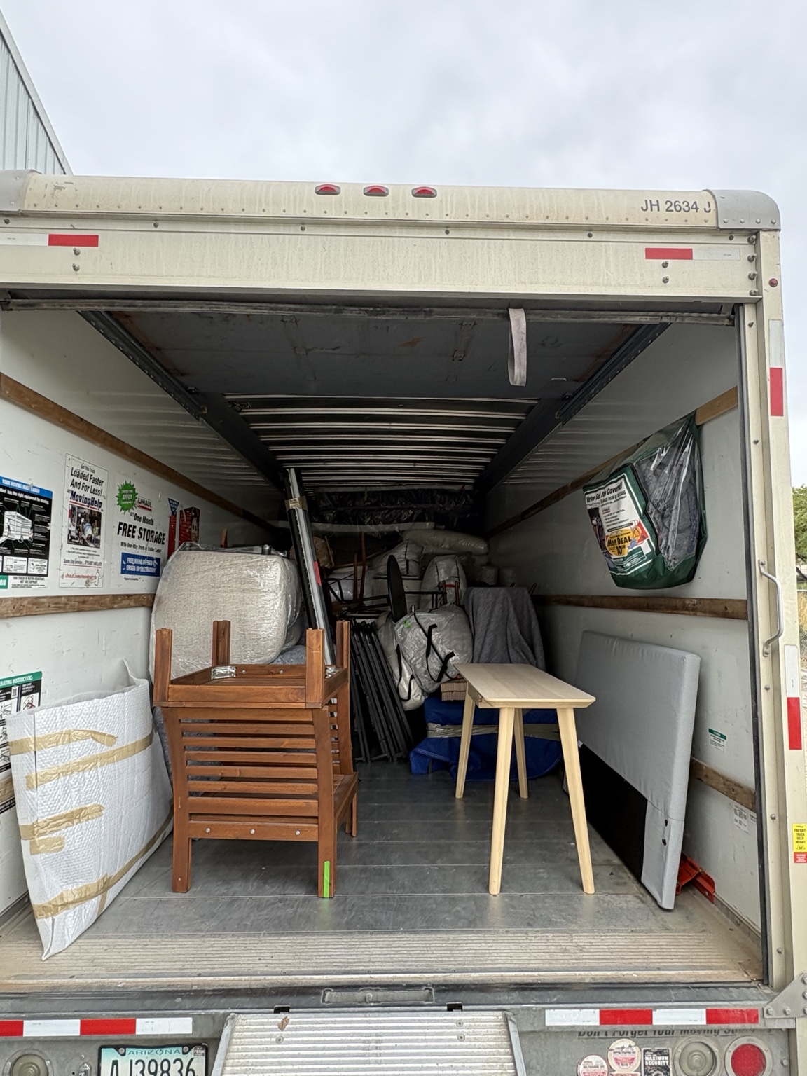 Tables, stacked chairs and protected staging furnishings filling more of the truck